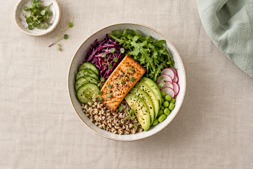 Overhead view of a colorful grain bowl on a plain linen tablecloth with nothing else in the frame